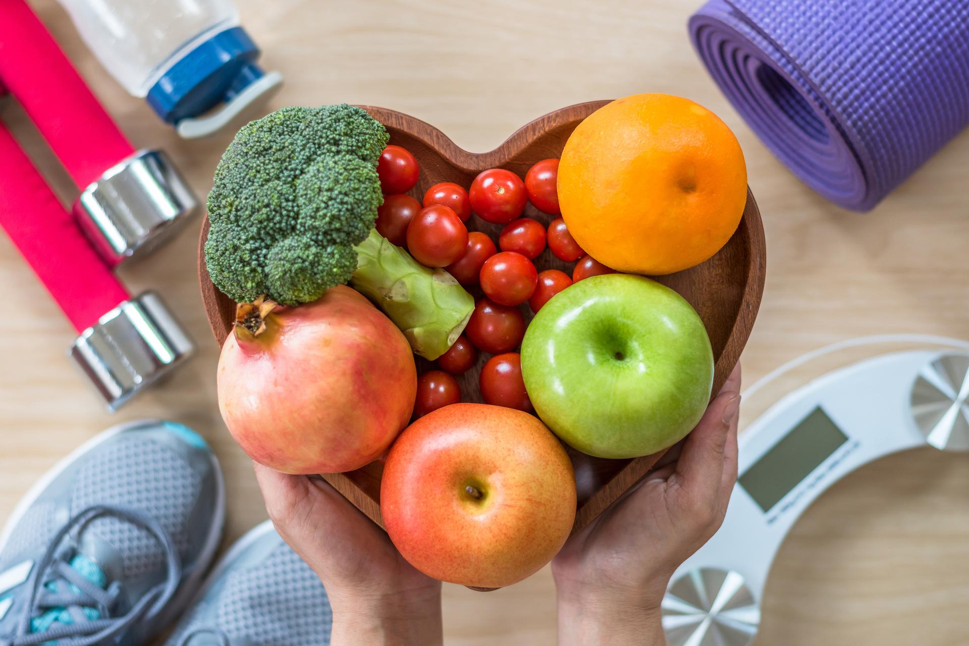 Concepto de estilo de vida saludable, comida limpia buena salud dietética en plato de corazón con equipo de gimnasio deportivo cuerpo aeróbico ejercicio entrenamiento entrenamiento clase, zapatos de deportes y escala de peso en gimnasio